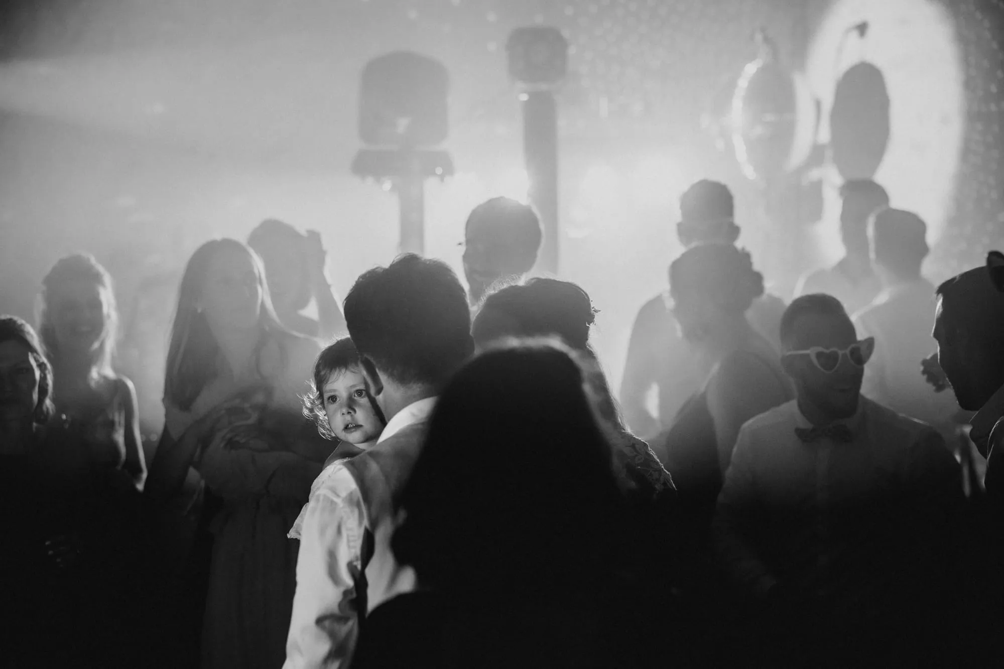 Foule d'invités en noir et blanc dans un halo de lumière