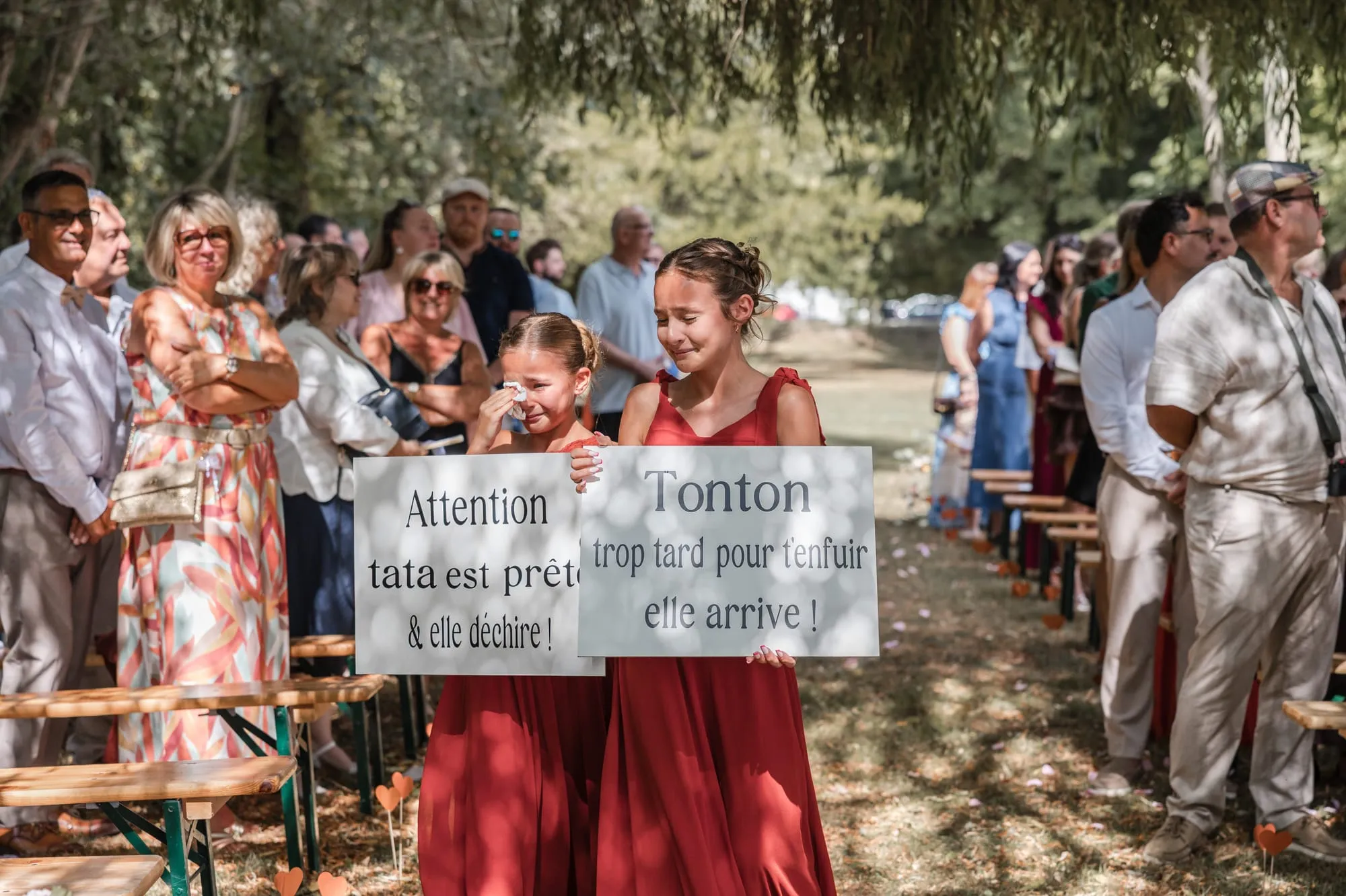 Invités en haie d'honneur avec des pancartes d'enfants