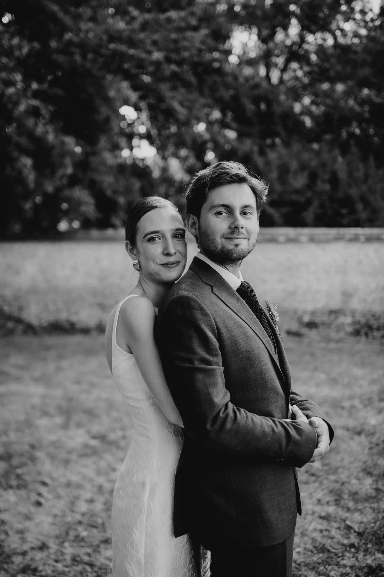 Mariés enlacés, la mariée la tête contre l'épaule du marié, en noir et blanc
