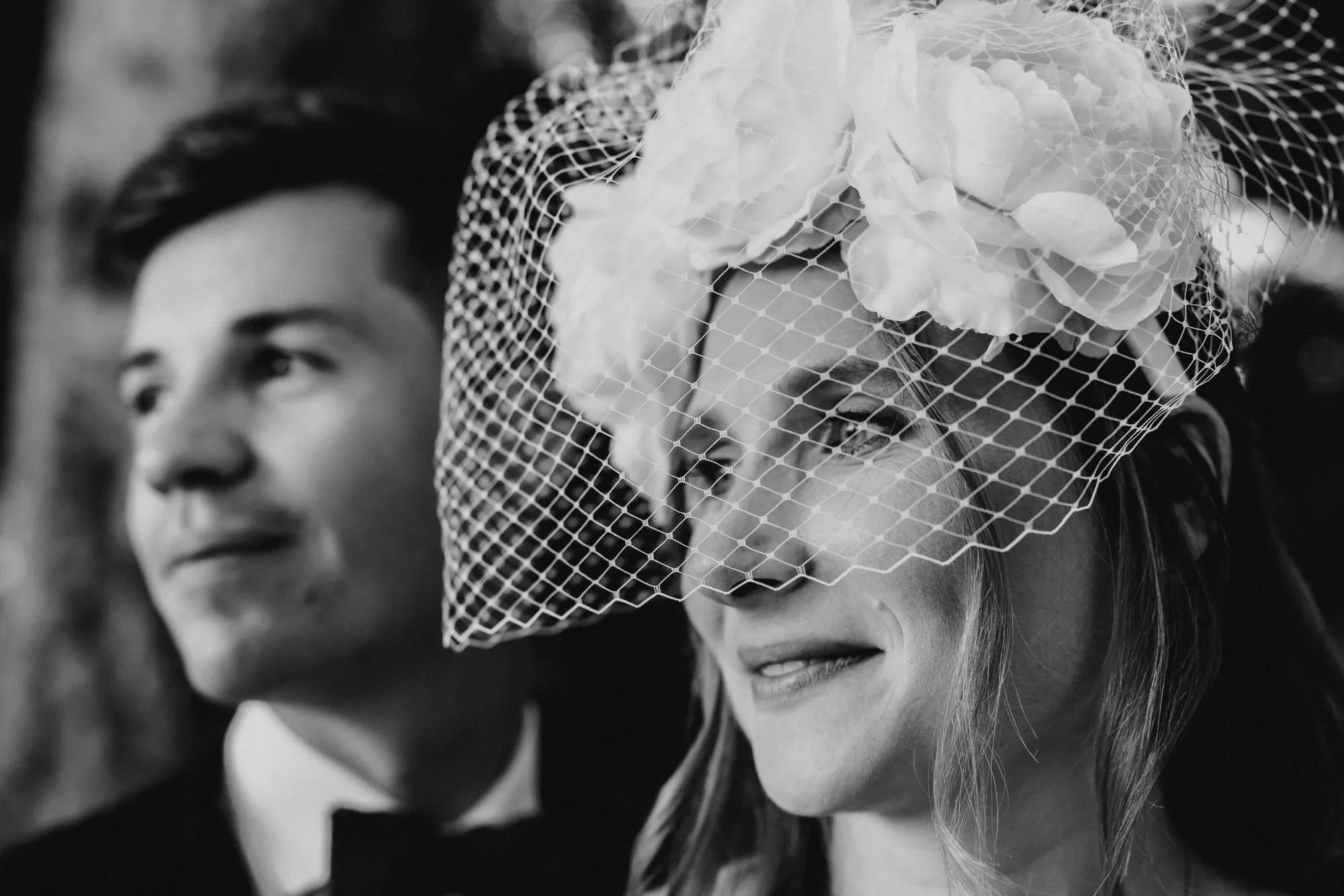 Portrait en noir et blanc d'un marié et d'une mariée coiffée d'une voilette à fleurs