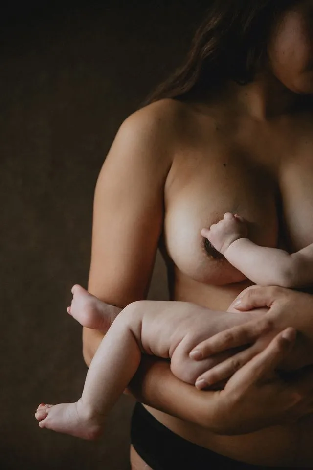 Bébé posant sa main sur le sein de sa mère pendant la tétée