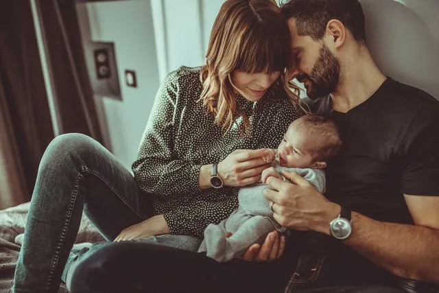 Jeunes parents attendris devant leur nouveau-né