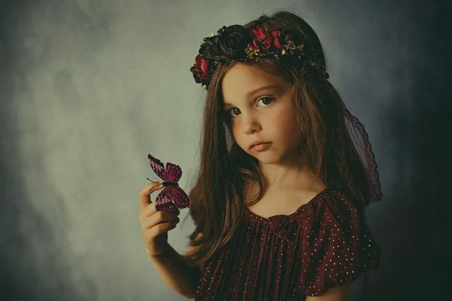 Portrait d'enfant avec une couronne de fleurs et un papillon