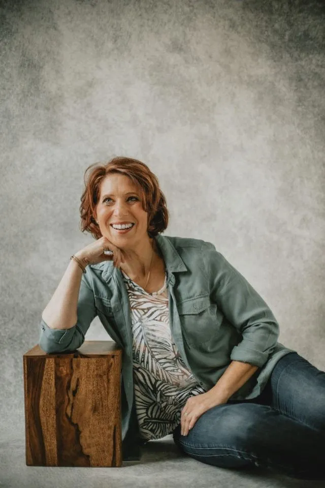 Portrait de femme souriante, pose décontractée en studio