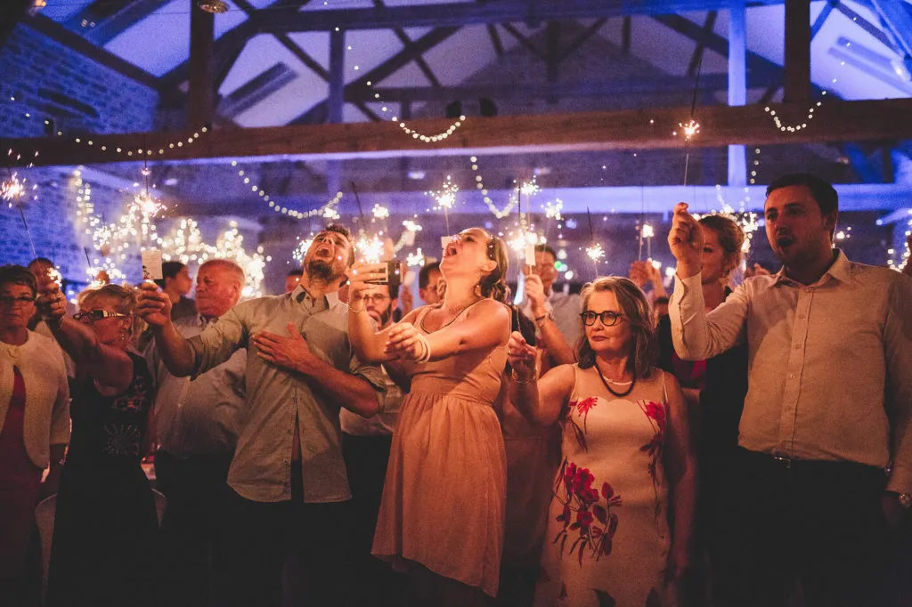 Invités et sparklers en soirée de mariage