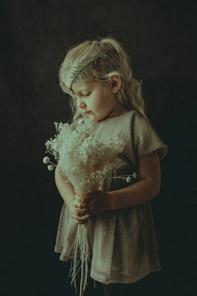 Portrait d'enfant avec un bouquet de fleurs séchées, réalisé au studio de Verrières en lumière naturelle