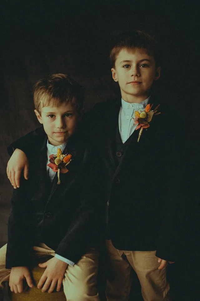 Portrait de deux frères en costume, boutonnières de fleurs séchées, en studio
