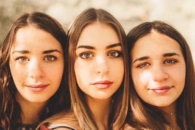 Portrait rapproché de trois sœurs, visages serrés
